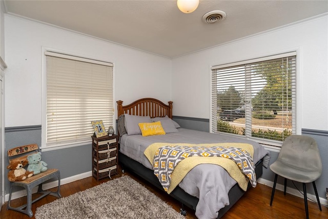 bedroom with dark hardwood / wood-style flooring and ornamental molding