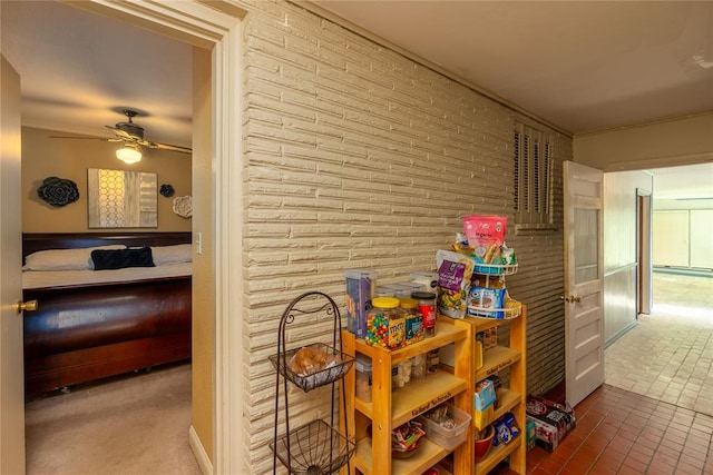 recreation room with ceiling fan and brick wall