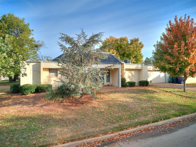 view of front of home with a front lawn and a garage