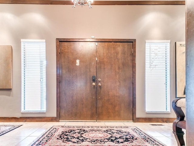 foyer entrance featuring light tile patterned floors and a healthy amount of sunlight