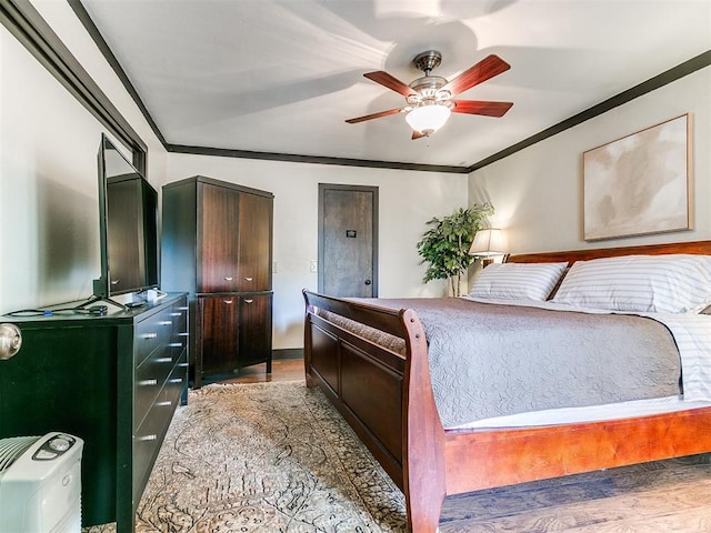 bedroom featuring ceiling fan, light hardwood / wood-style flooring, and crown molding