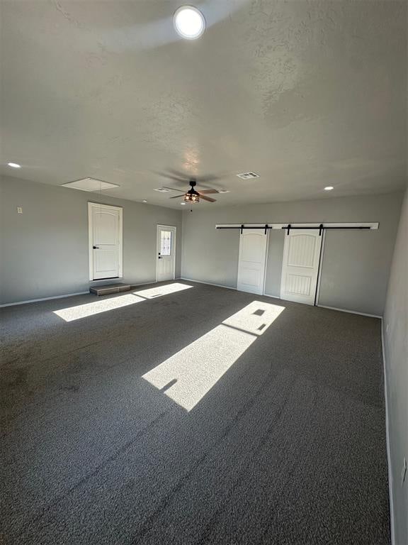 unfurnished room featuring ceiling fan and dark carpet