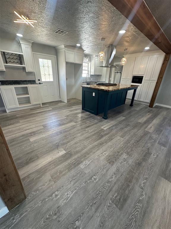 kitchen featuring white cabinets, dark hardwood / wood-style flooring, a breakfast bar, and a kitchen island