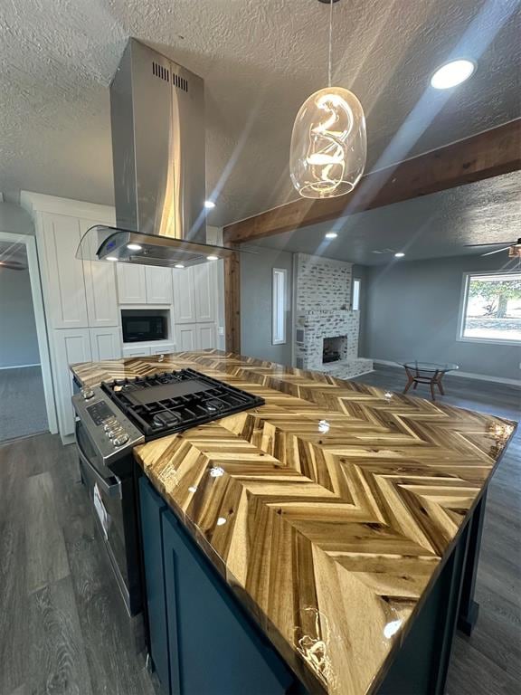 kitchen with a textured ceiling, dark hardwood / wood-style floors, hanging light fixtures, and exhaust hood