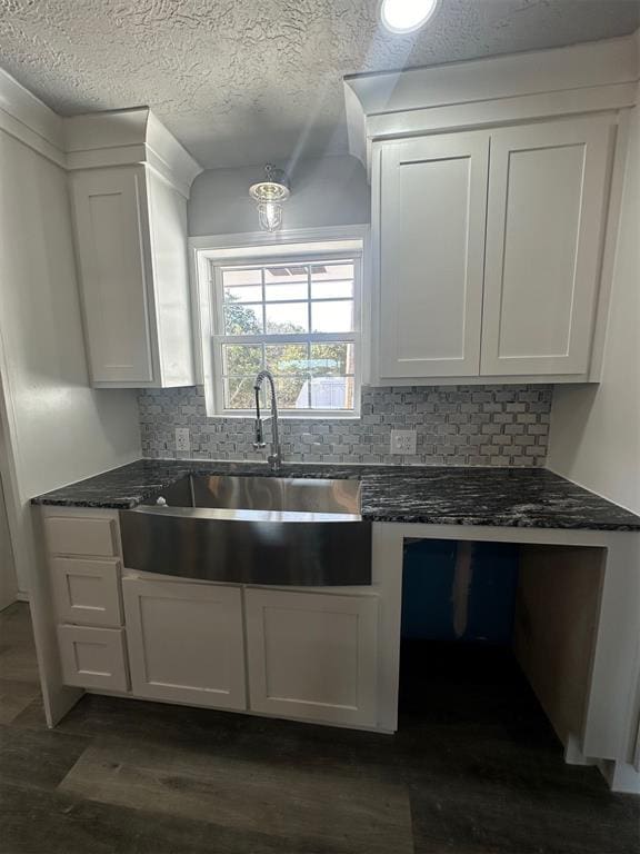 kitchen with dark hardwood / wood-style floors, white cabinetry, sink, and tasteful backsplash