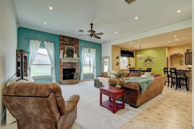 tiled living room featuring crown molding, a fireplace, a healthy amount of sunlight, and ceiling fan with notable chandelier