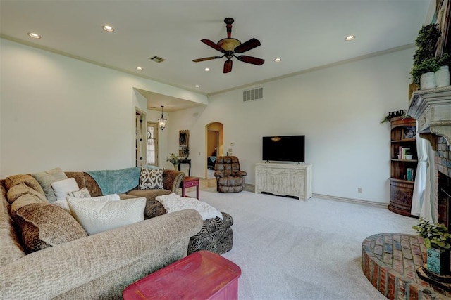 carpeted living room with ceiling fan, a fireplace, and ornamental molding