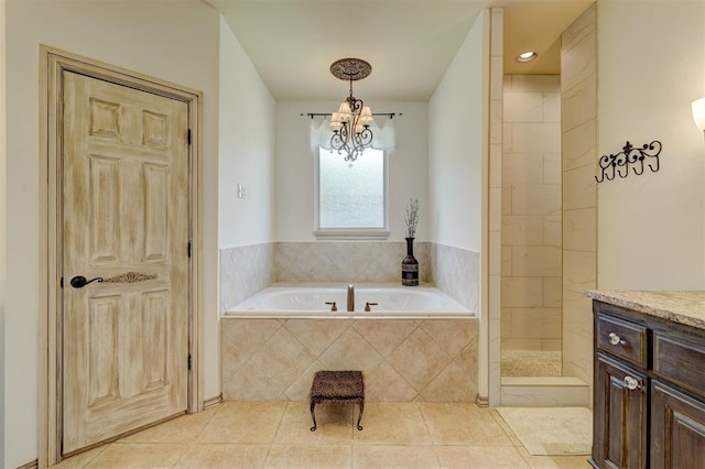 bathroom with tile patterned flooring, vanity, independent shower and bath, and a notable chandelier