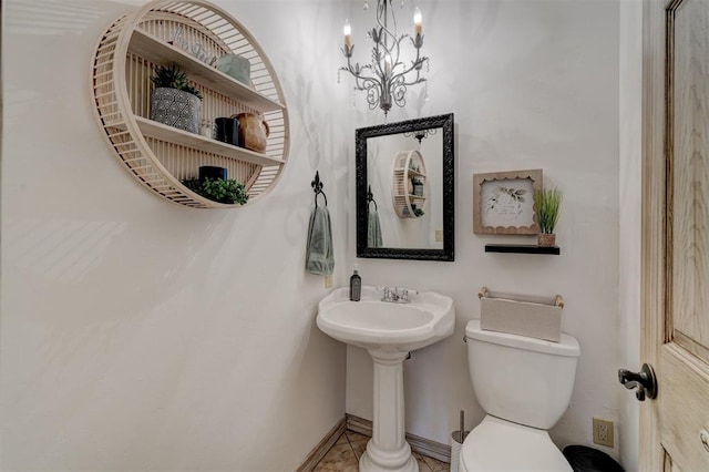 bathroom featuring tile patterned floors, a notable chandelier, and toilet