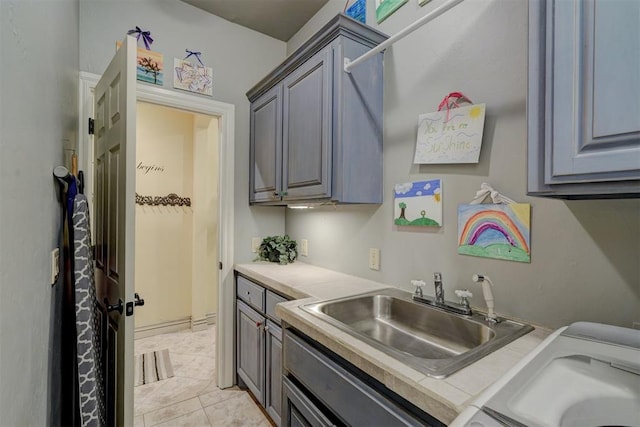 kitchen with light tile patterned floors, gray cabinets, and sink