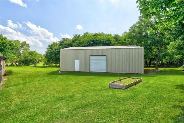 view of outdoor structure featuring a garage and a lawn