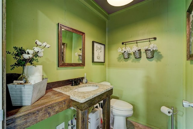 bathroom featuring crown molding, vanity, and toilet