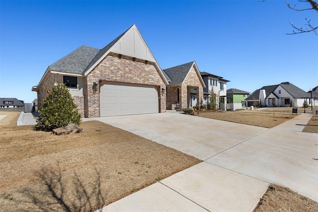 view of front facade with a residential view, concrete driveway, a shingled roof, a garage, and brick siding