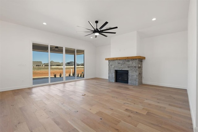 unfurnished living room featuring a stone fireplace, recessed lighting, light wood-style floors, and ceiling fan