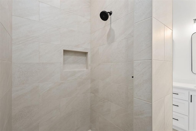 full bathroom featuring vanity and a tile shower