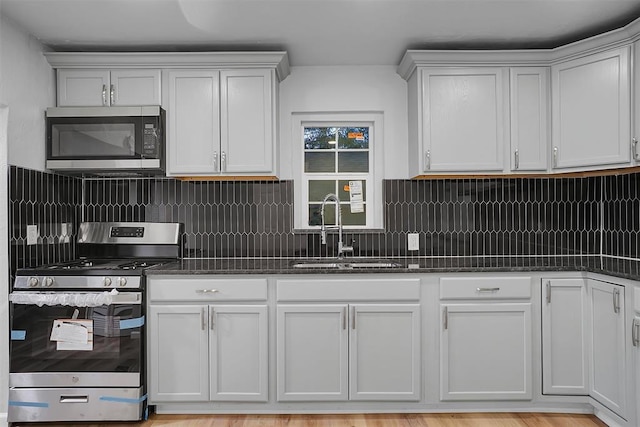 kitchen with dark stone countertops, white cabinetry, sink, and appliances with stainless steel finishes