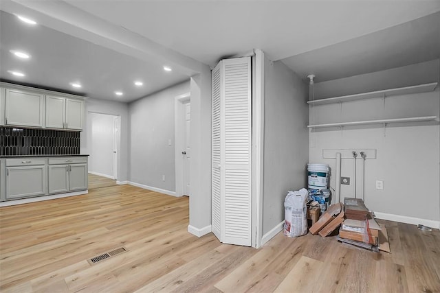 interior space featuring decorative backsplash and light wood-type flooring