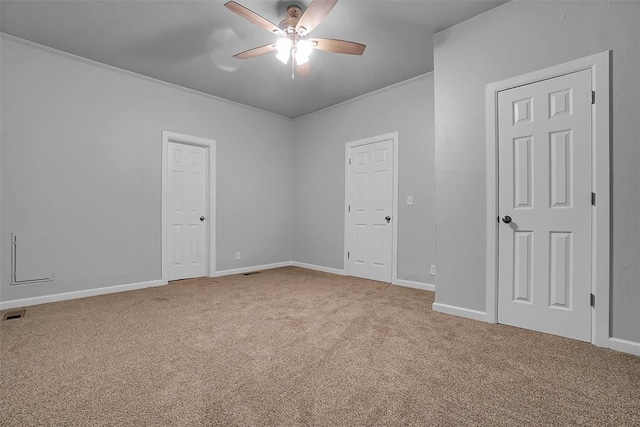 spare room featuring carpet floors, ceiling fan, and crown molding