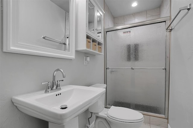 bathroom featuring toilet, sink, and walk in shower