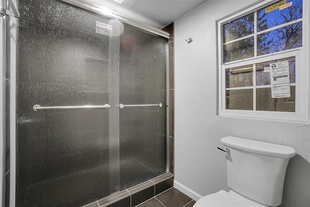 bathroom featuring tile patterned flooring, an enclosed shower, and toilet