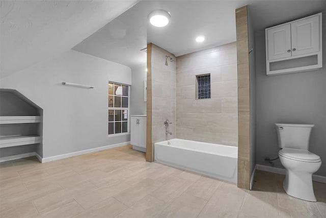 bathroom with tiled shower / bath combo and toilet