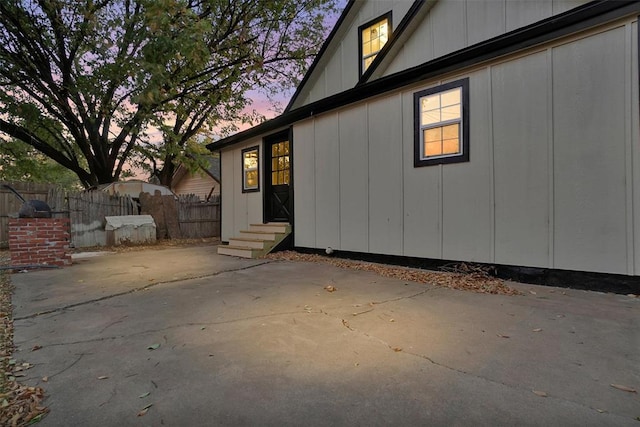 property exterior at dusk featuring a patio area