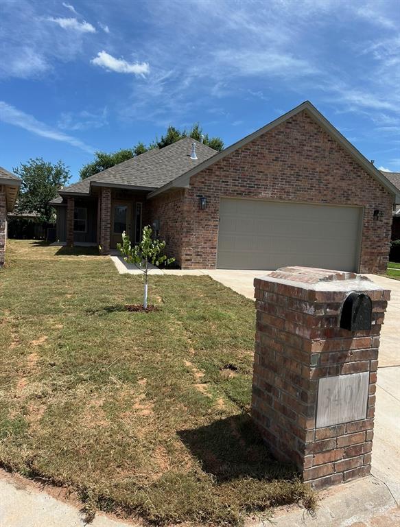 ranch-style home with a front yard and a garage