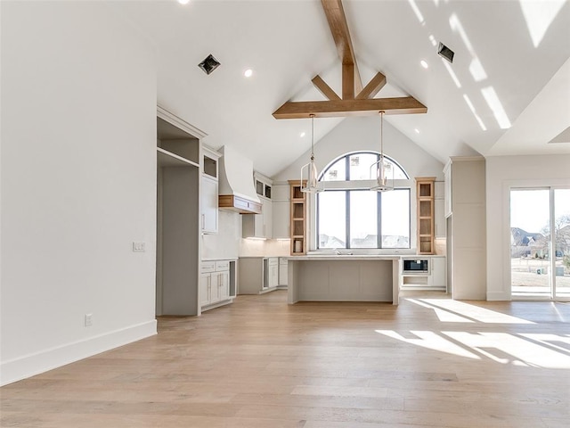 unfurnished living room with beam ceiling, visible vents, light wood-style floors, high vaulted ceiling, and baseboards