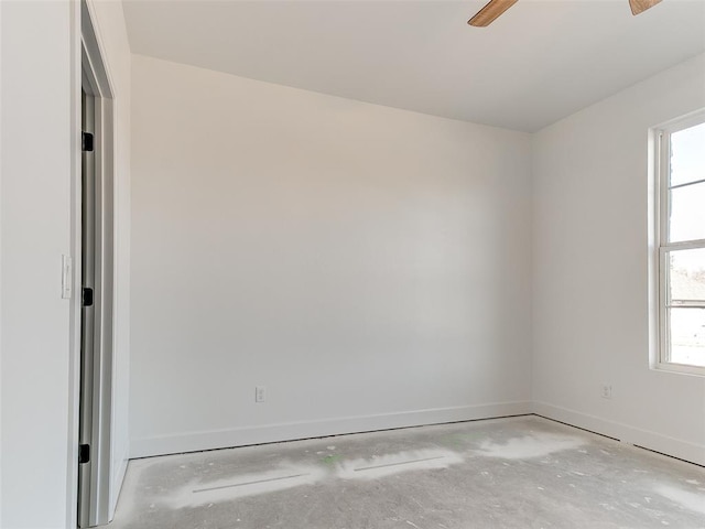 unfurnished room featuring ceiling fan, concrete floors, and baseboards