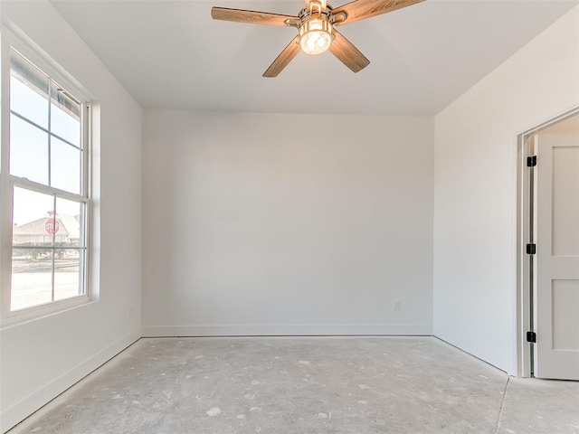 unfurnished room featuring a ceiling fan, a wealth of natural light, and baseboards