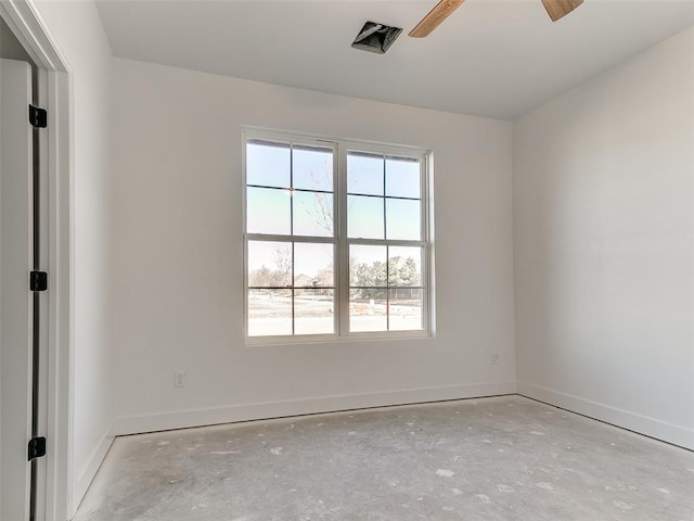 spare room with ceiling fan, unfinished concrete flooring, and baseboards