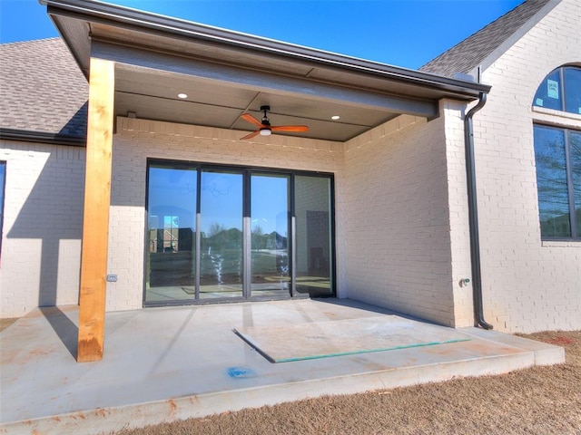 back of property with ceiling fan, brick siding, and a patio area