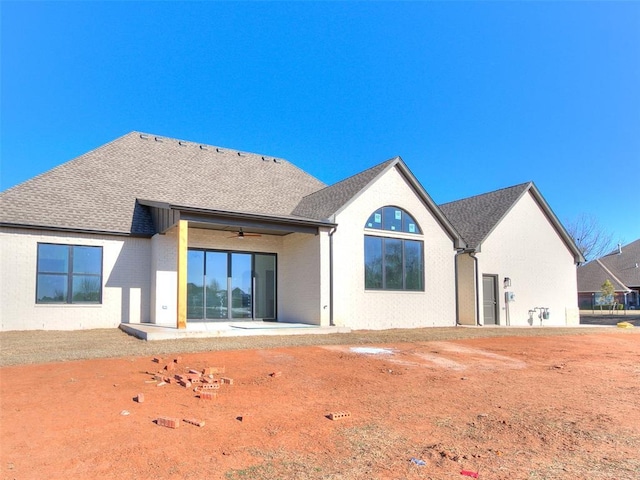 rear view of house featuring a patio area, a shingled roof, ceiling fan, and brick siding