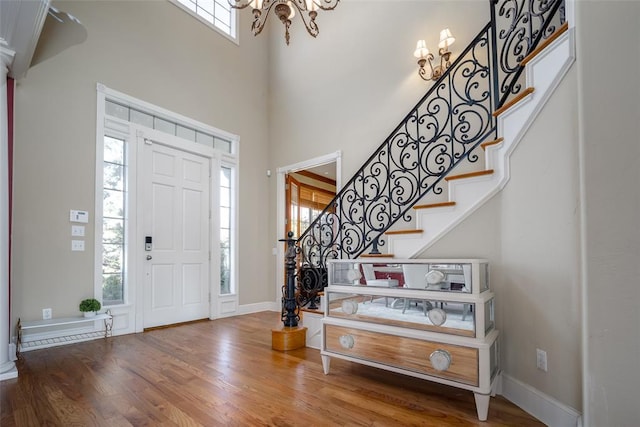 entryway with a notable chandelier, a high ceiling, and hardwood / wood-style floors