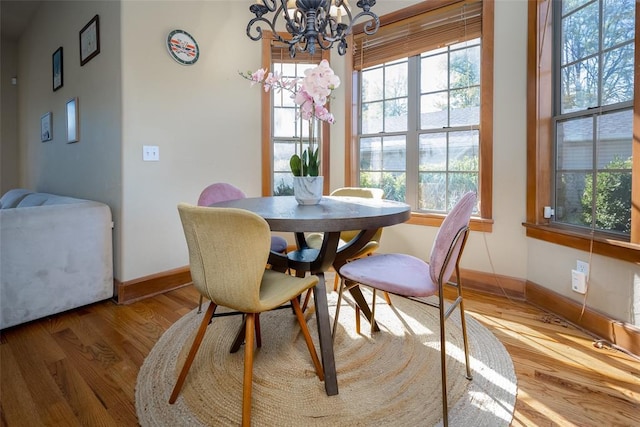 dining space with hardwood / wood-style flooring and a notable chandelier