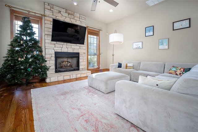 living room with a fireplace, hardwood / wood-style floors, ceiling fan, and a healthy amount of sunlight