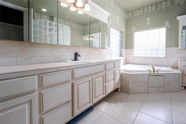 bathroom with tiled bath, tile patterned floors, and sink