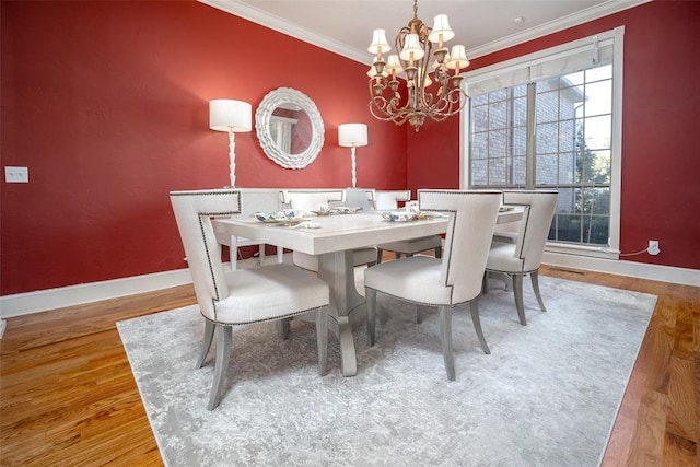 dining room with a chandelier, ornamental molding, and hardwood / wood-style floors