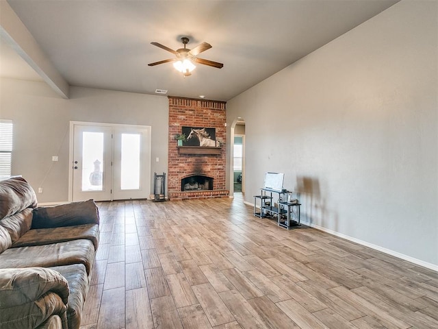 living room featuring ceiling fan, light hardwood / wood-style floors, and a fireplace