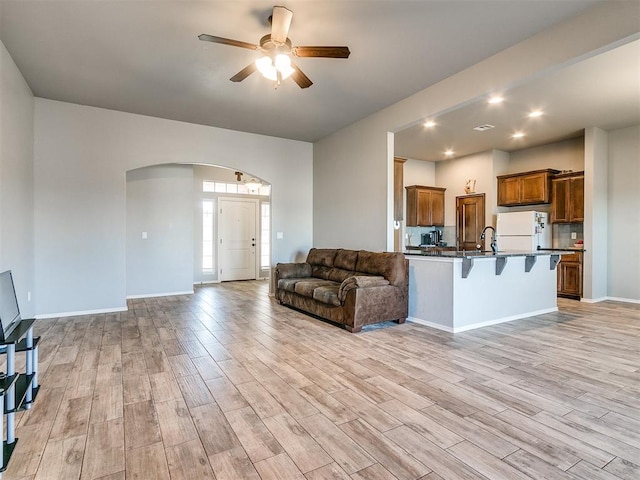 unfurnished living room featuring ceiling fan and light wood-type flooring