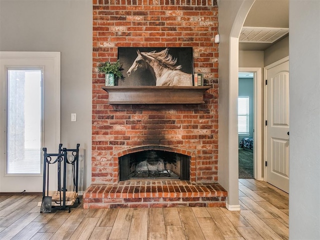 living room featuring light hardwood / wood-style floors and a brick fireplace