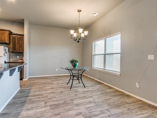 unfurnished dining area featuring light hardwood / wood-style flooring and a notable chandelier