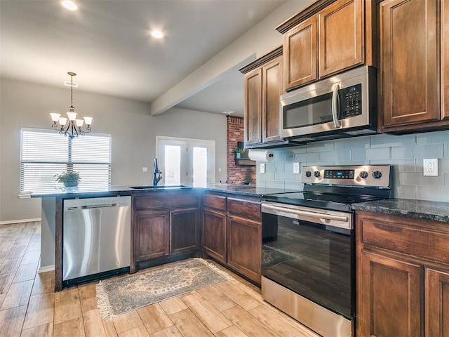 kitchen featuring sink, stainless steel appliances, beamed ceiling, a chandelier, and light wood-type flooring