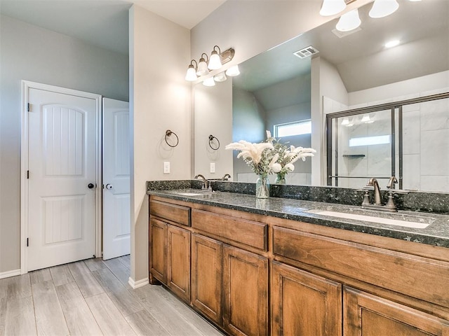 bathroom featuring walk in shower, vanity, and hardwood / wood-style flooring