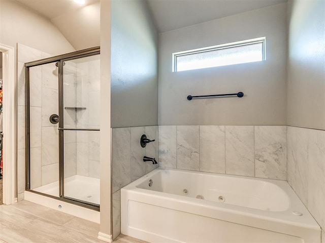 bathroom with hardwood / wood-style floors, lofted ceiling, and plus walk in shower