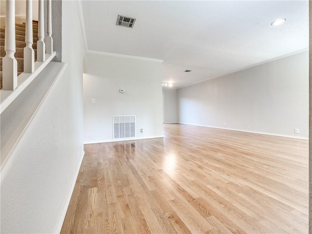 unfurnished living room featuring crown molding and light wood-type flooring