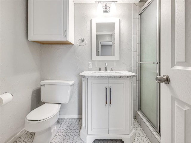 bathroom featuring tile patterned flooring, vanity, toilet, and a shower with door