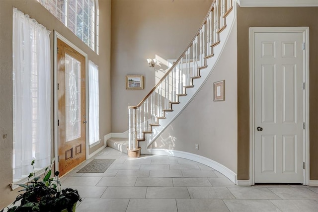 foyer featuring light tile patterned floors and a high ceiling