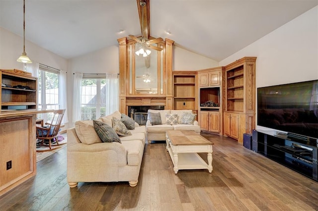 living room with hardwood / wood-style floors, lofted ceiling with beams, a large fireplace, and ceiling fan