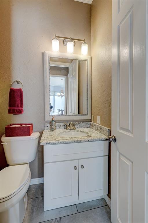 bathroom featuring tile patterned flooring, vanity, and toilet